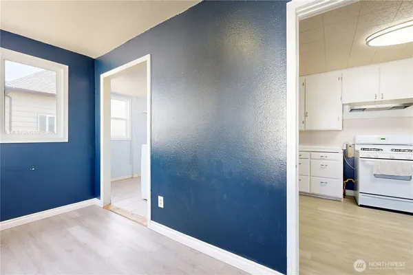 a view of a kitchen with white cabinets and wooden floor