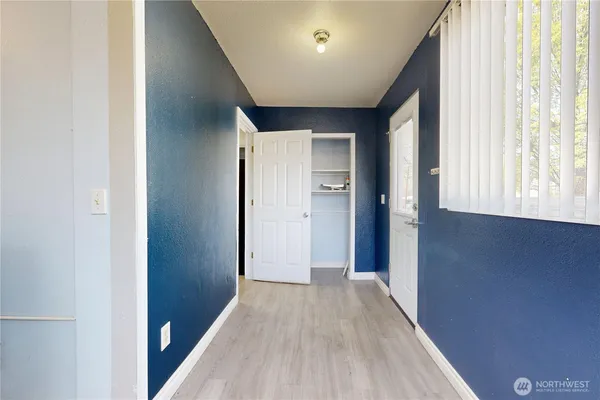a view of hallway with a window and wooden floor