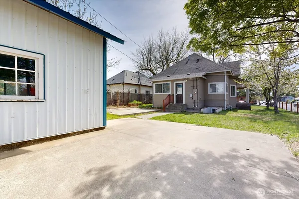 a view of house with yard and large tree