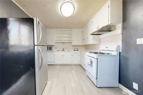 a kitchen with white cabinets and white appliances