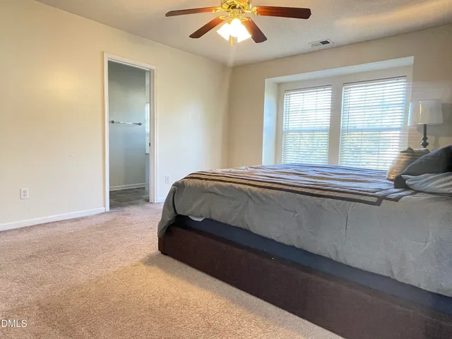 a bedroom with a bed and a large window
