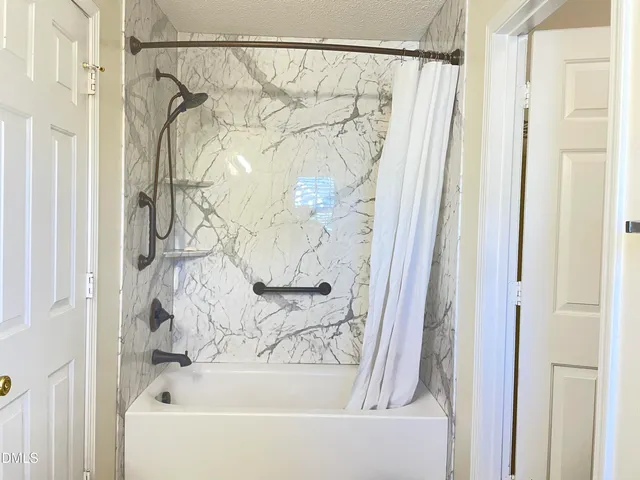 a bathroom with a shower curtain and a bathtub