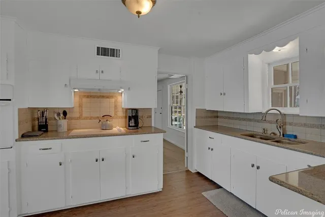 a kitchen with granite countertop a sink a stove and cabinets