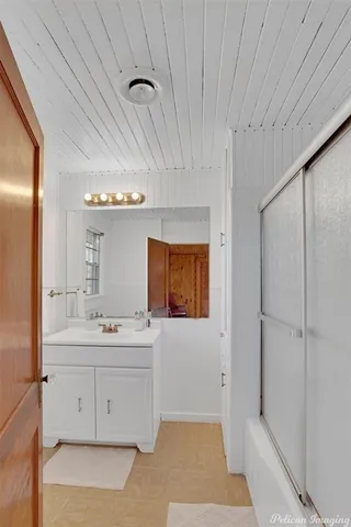 a bathroom with a double vanity sink a toilet and mirror