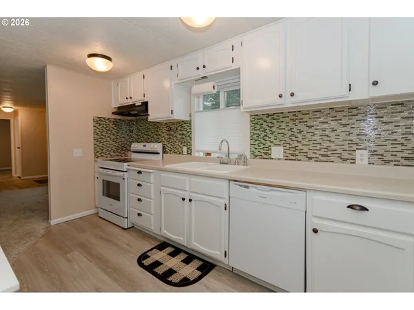 a kitchen with granite countertop white cabinets and white appliances