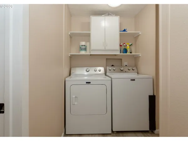 a view of an empty room with kitchen and a window