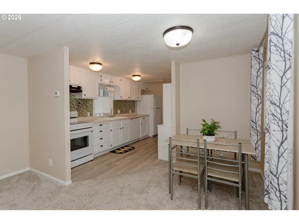 a kitchen with kitchen island a stove a table and chairs in it