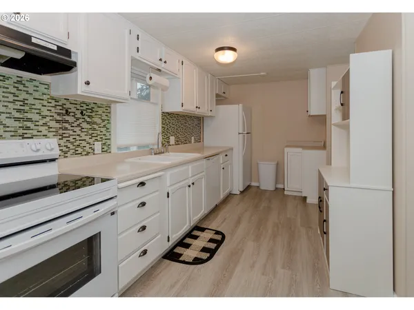 a kitchen with white cabinets and appliances