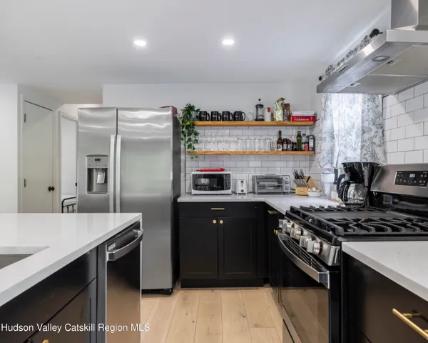 a kitchen with stainless steel appliances granite countertop a stove a sink and a refrigerator