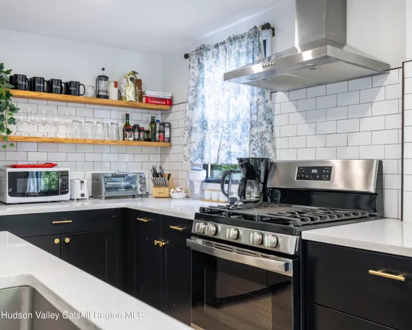 a kitchen with stainless steel appliances a sink stove and cabinets