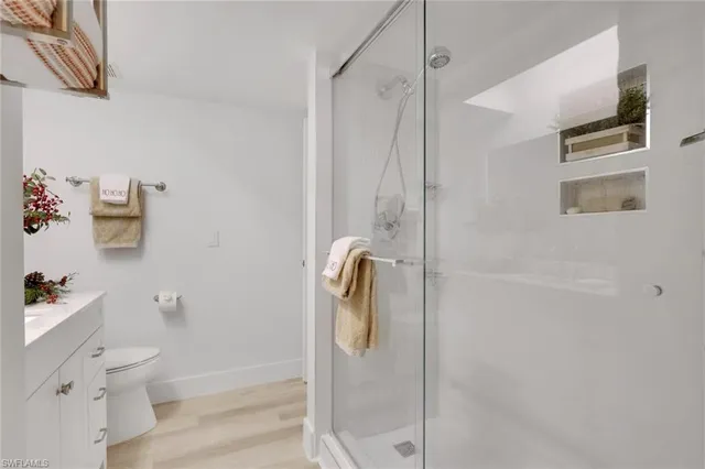 a spacious bathroom with a granite countertop sink a potted plant and a shower