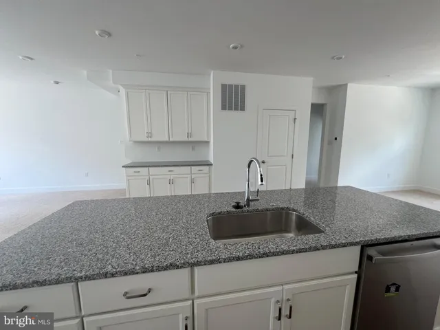 a kitchen with granite countertop a sink and cabinets