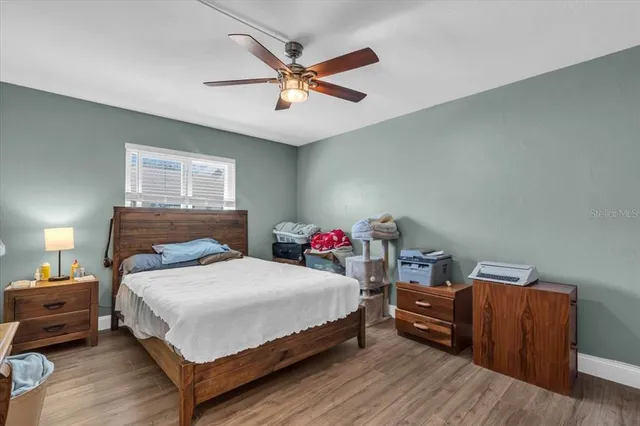 a bedroom with a bed and wooden floor