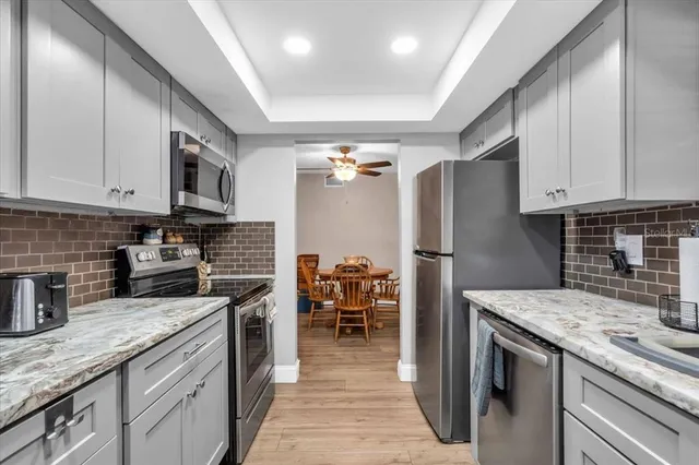 a kitchen with stainless steel appliances granite countertop a refrigerator a stove and a sink