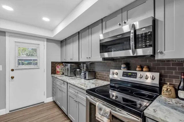 a kitchen with stainless steel appliances granite countertop a stove a sink and a microwave