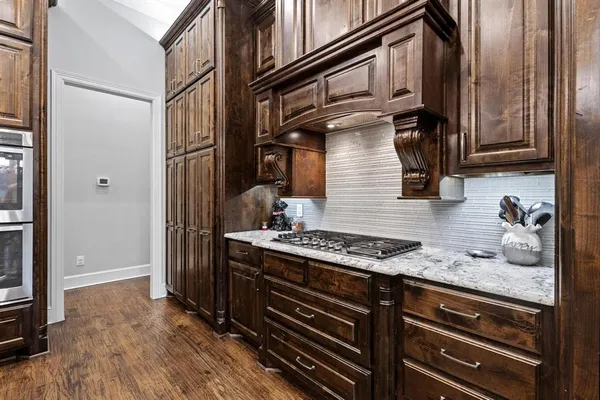 a kitchen with granite countertop a stove and cabinets