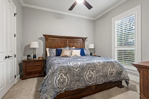 a bed sitting in a bedroom next to a window and a chandelier