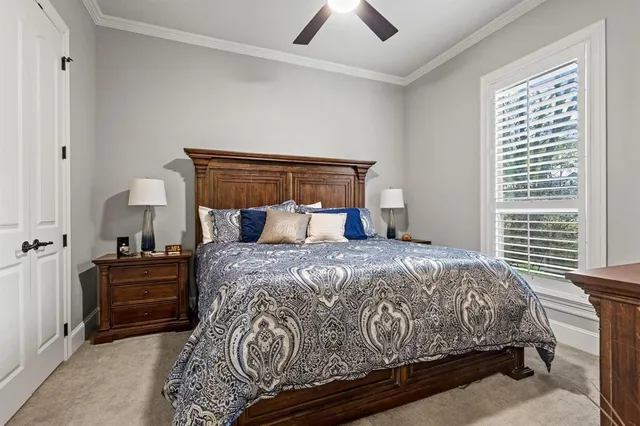 a bed sitting in a bedroom next to a window and a chandelier