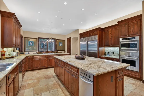 a kitchen with stainless steel appliances granite countertop a stove a sink dishwasher and cabinets with wooden floor