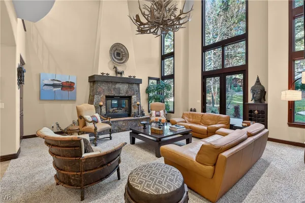 a living room with furniture a chandelier and a fireplace