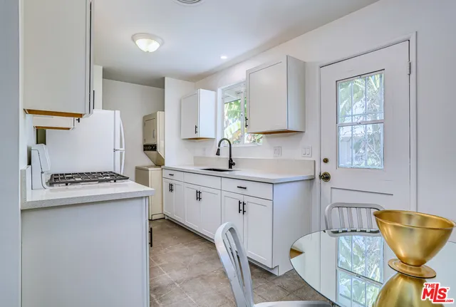 a kitchen with stainless steel appliances granite countertop a stove a sink a microwave a refrigerator and cabinets