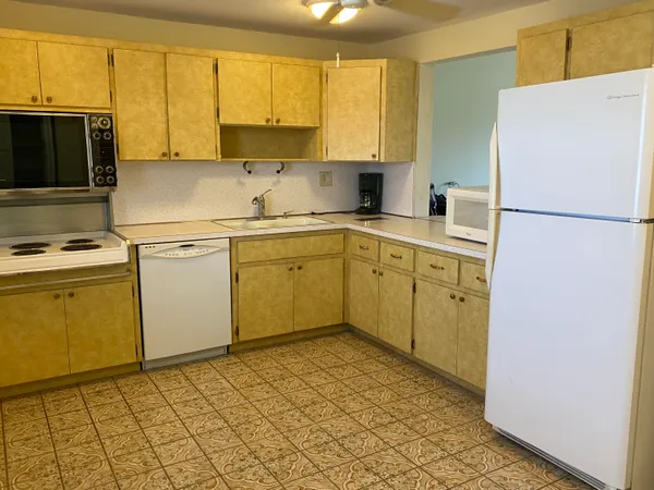 a kitchen with a refrigerator sink and cabinets