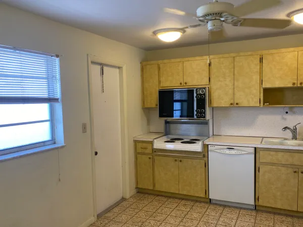 a kitchen with a sink cabinets and window