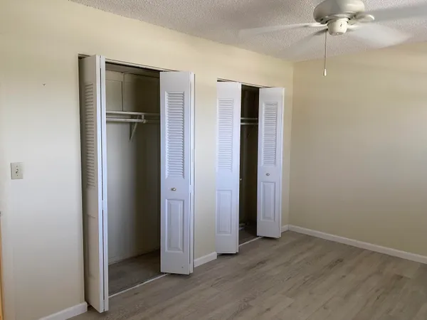an empty room with wooden floor and closet area