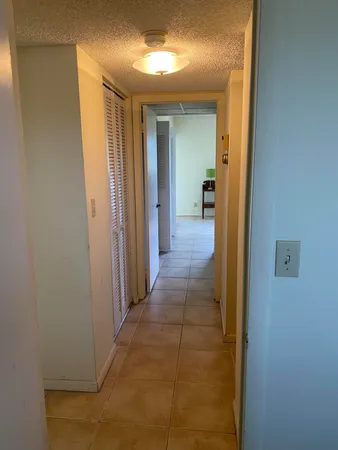 a view of a hallway with wooden shelves