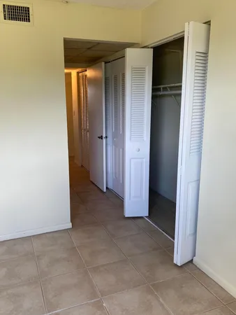 an empty room with closet and a bathroom