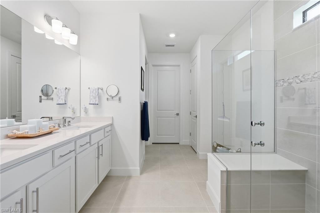 18364 Ridgeline Drive Estero, FL 33928 - Photo 24 of 50 a spacious bathroom with a granite countertop sink a mirror and shower