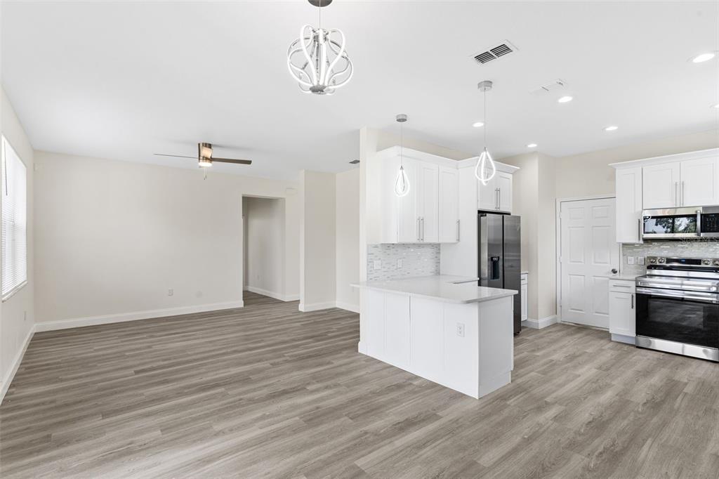 5424 Hammock View Lane Apollo Beach, FL 33572 - Photo 13 of 55 a kitchen with stainless steel appliances a refrigerator and a stove top oven