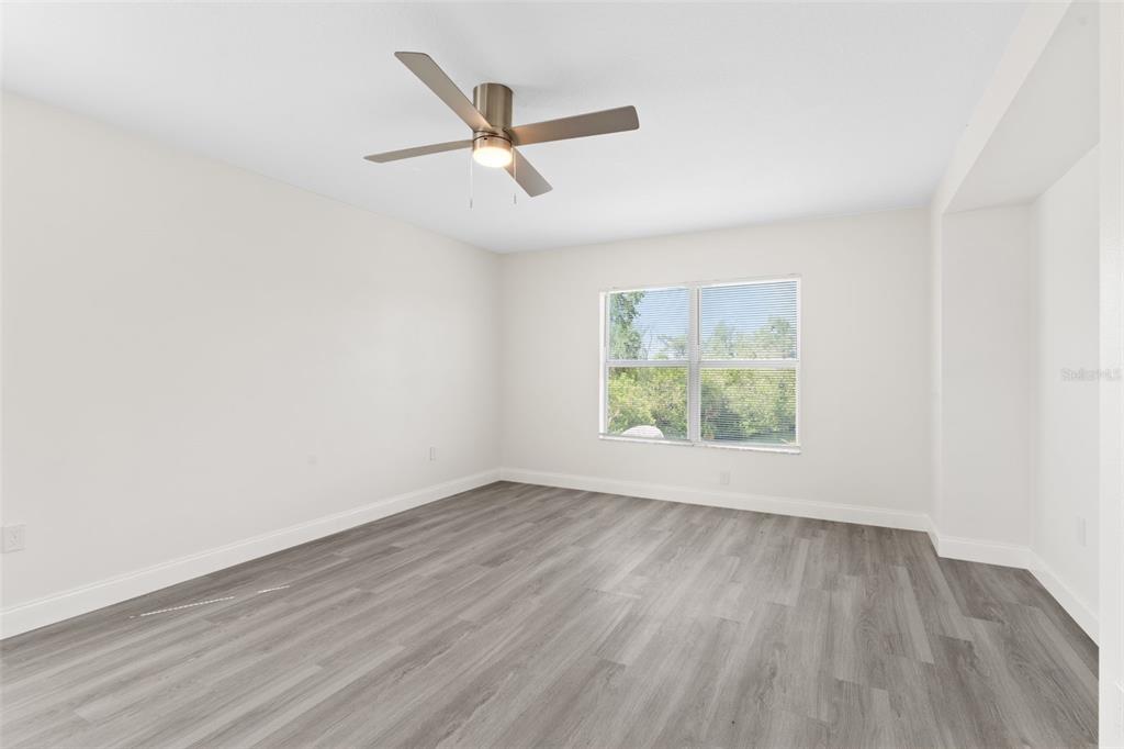 5424 Hammock View Lane Apollo Beach, FL 33572 - Photo 29 of 55 an empty room with wooden floor ceiling fan and windows