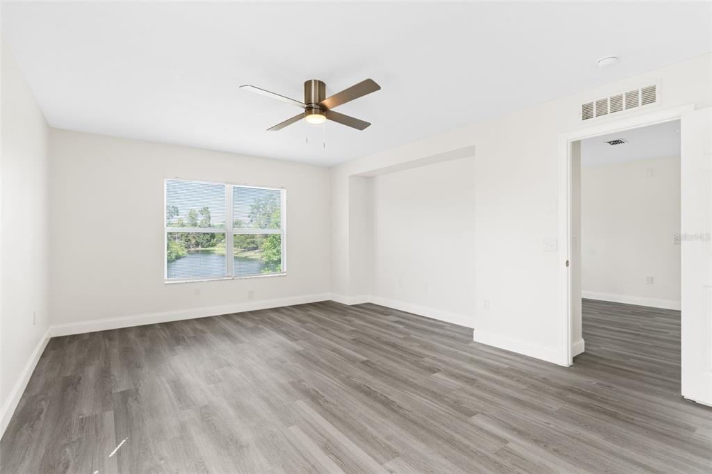 5424 Hammock View Lane Apollo Beach, FL 33572 - Photo 31 of 55 a view of an empty room with wooden floor and a ceiling fan