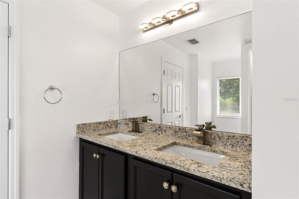 5424 Hammock View Lane Apollo Beach, FL 33572 - Photo 32 of 55 a bathroom with a granite countertop sink and a mirror