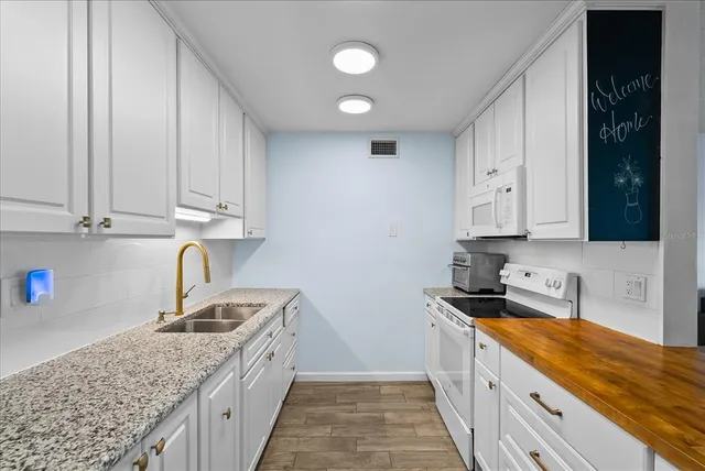 a kitchen with stainless steel appliances granite countertop a sink stove and cabinets