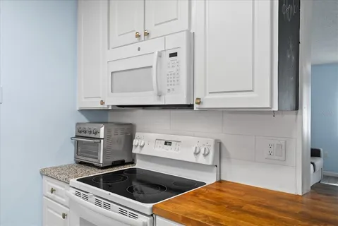 a kitchen with granite countertop a refrigerator and a sink