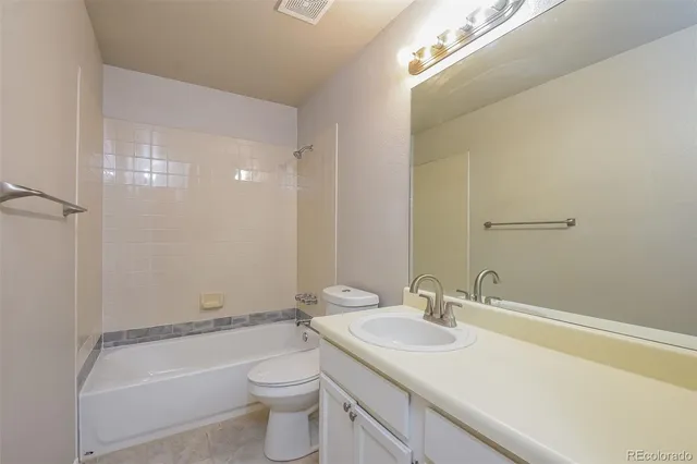 a bathroom with a granite countertop sink a toilet and shower