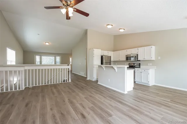 a view of kitchen with wooden floor and electronic appliances