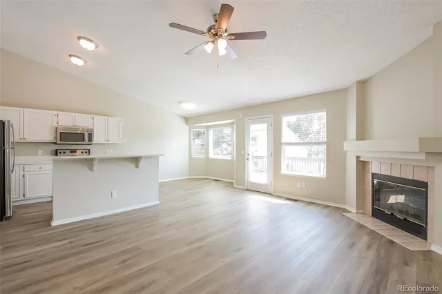 a view of an empty room with window and wooden floor