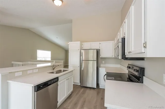 a kitchen with a sink a refrigerator and cabinets