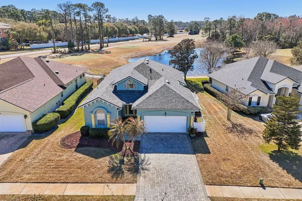a view of a house with a yard and large tree