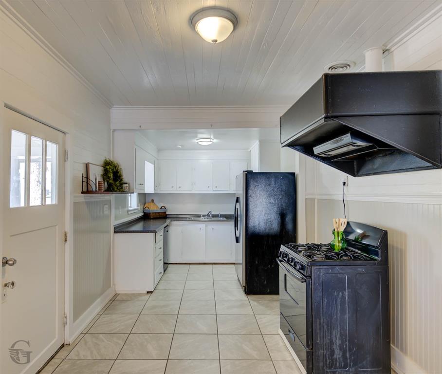 511 Chandler Street Minden, LA 71055 - Photo 6 of 16 a kitchen with a refrigerator and a stove top oven