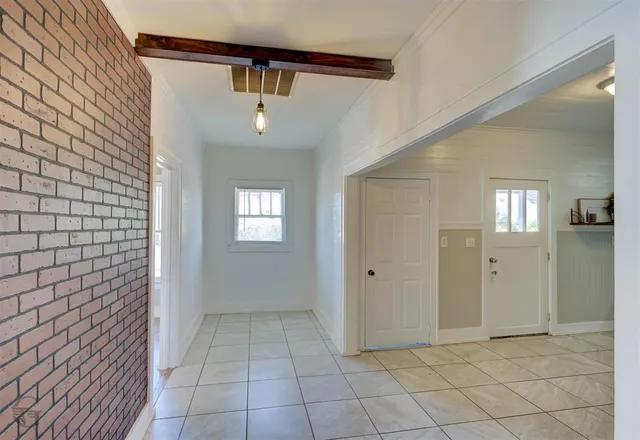 a view of a hallway with closet and a bathroom