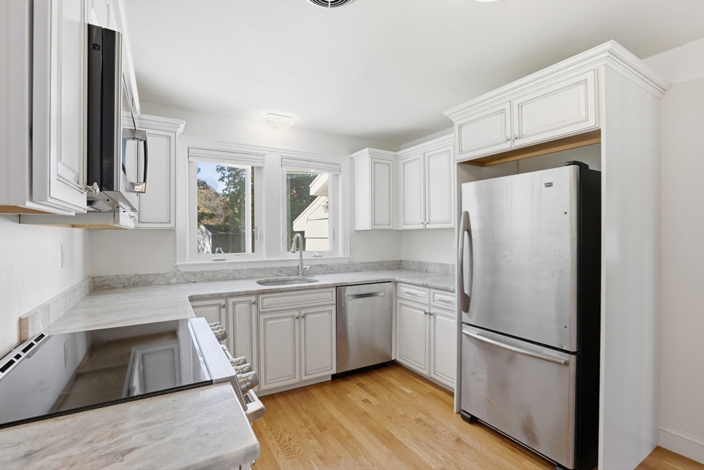 684 Haverhill Street Reading, MA 01867 - Photo 5 of 16 a white refrigerator freezer sitting inside of a kitchen