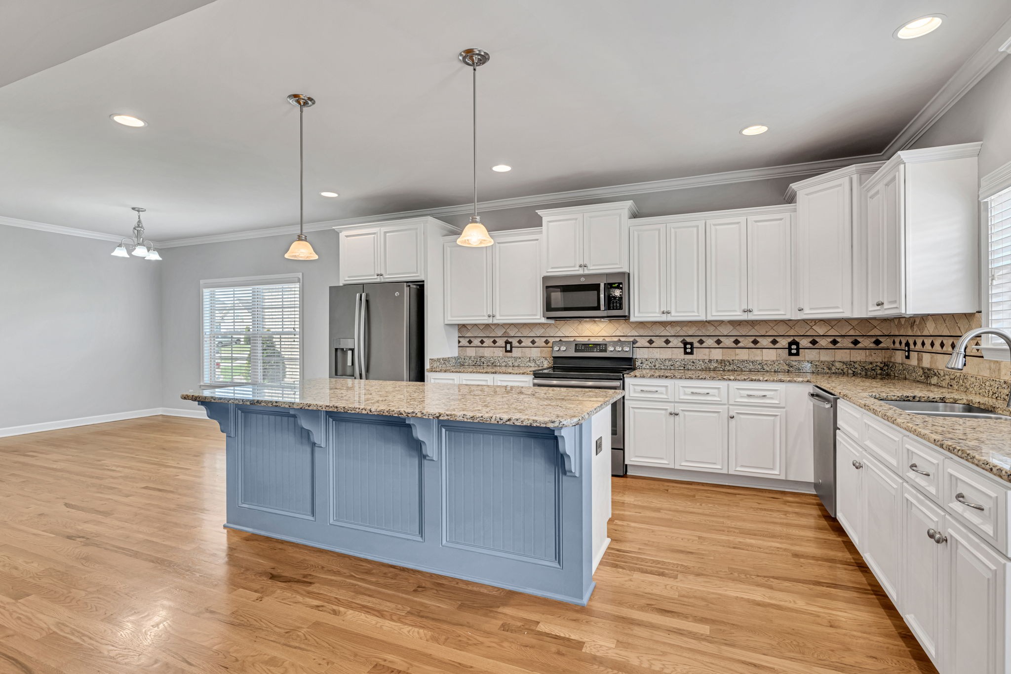 8023 Ragusa Circle Spring Hill, TN 37174 - Photo 14 of 46 a kitchen with kitchen island granite countertop a sink cabinets and wooden floor