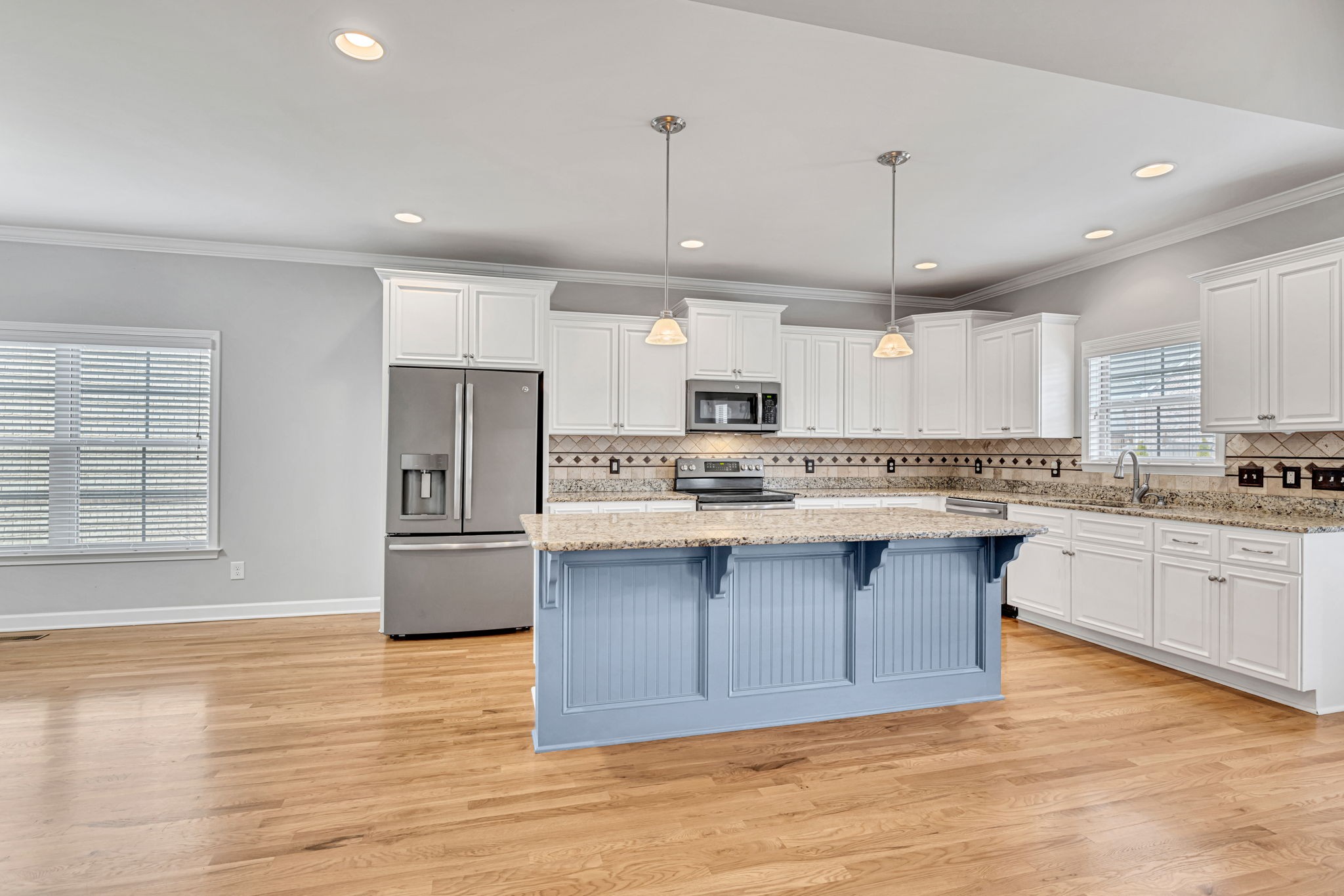 8023 Ragusa Circle Spring Hill, TN 37174 - Photo 15 of 46 a large kitchen with stainless steel appliances kitchen island granite countertop a large stove a sink dishwasher and a refrigerator with wooden floor