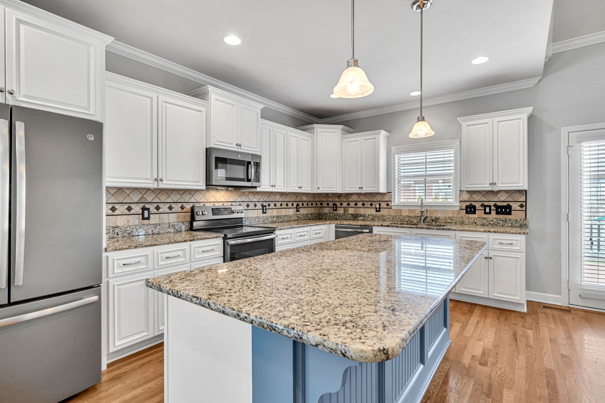 8023 Ragusa Circle Spring Hill, TN 37174 - Photo 16 of 46 a kitchen with kitchen island granite countertop stainless steel appliances and wooden cabinets