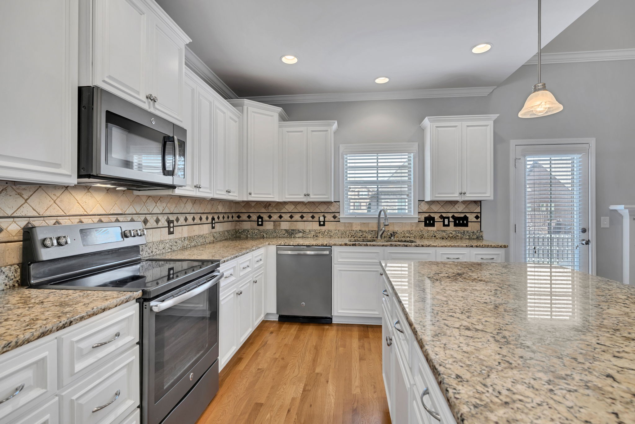 8023 Ragusa Circle Spring Hill, TN 37174 - Photo 18 of 46 a kitchen with stainless steel appliances granite countertop wooden cabinets a stove top oven a sink and dishwasher