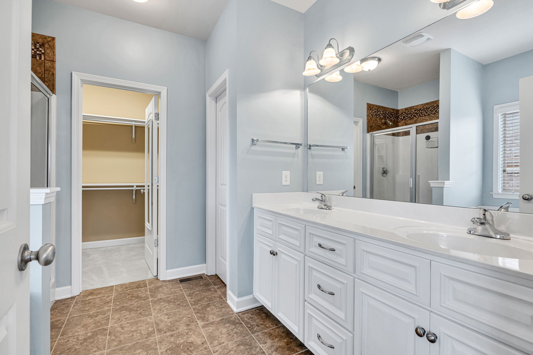8023 Ragusa Circle Spring Hill, TN 37174 - Photo 28 of 46 a spacious bathroom with a granite countertop sink a mirror and a shower